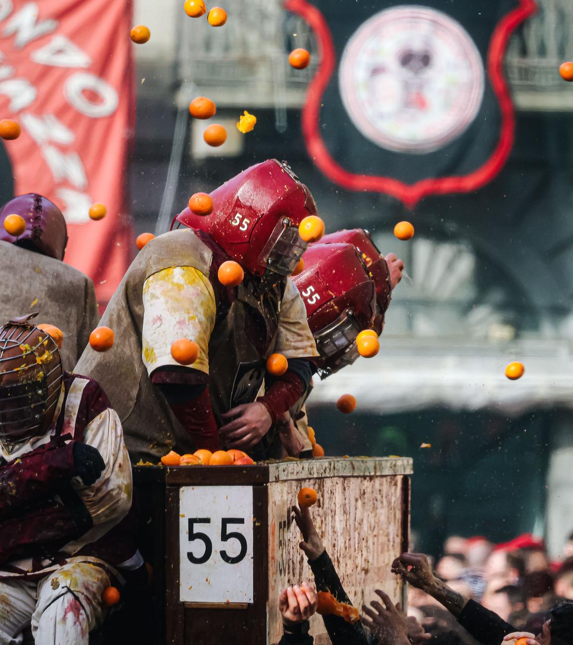 Mehrere Menschen werfen sich mit Orangen ab