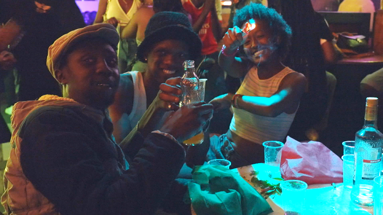 Drei junge Leute stoßen mit Jaba-Juice in einer Flasche an.