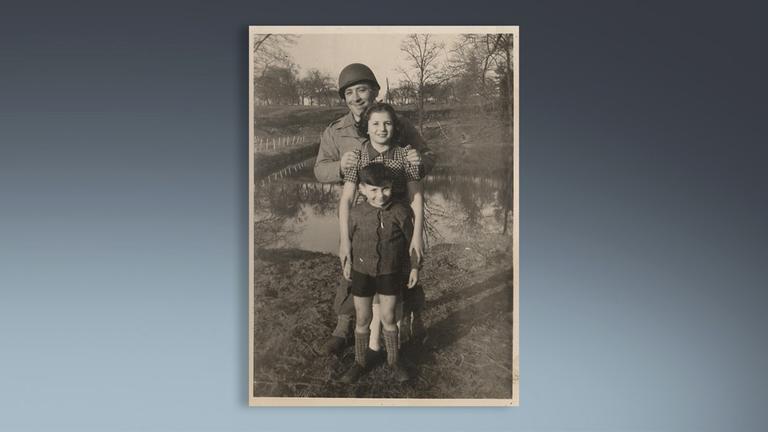 Jack Offen, seine Schwester und ein Soldat stehen nach Kriegsende zusammen.