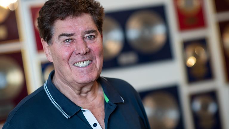 Jack White, Musikproduzent, steht in seiner Wohnung in Berlin-Charlottenburg, an der Wand hängen zahlreiche Goldene Schallplatten.