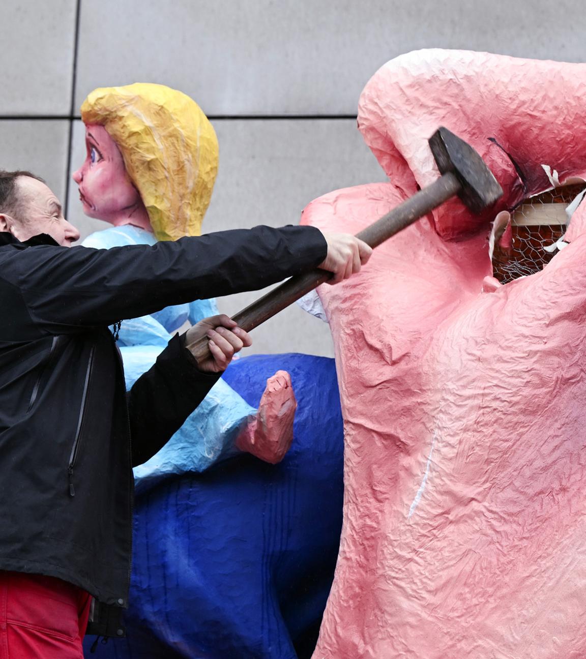 Der Wagenbauer Jacques Tilly schlägt mit einem Vorschlaghammer auf eine Putin-Figur ein die auf seinem eigenen Mottowagen während des Rosenmontagszugs in Düsseldorf am 17.02.2026 gezeigt wird.