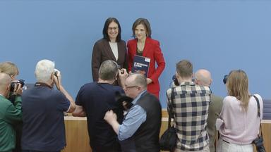 Elisabeth Kaiser mit Jahresbericht in der Hand, bei einer Pressekonferenz