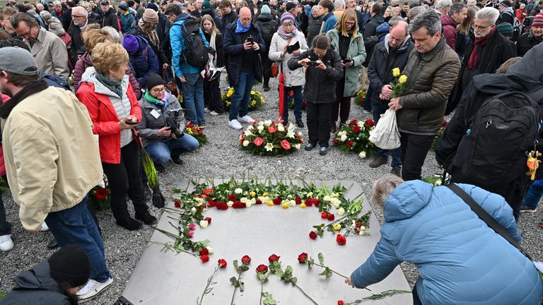12.04.2026, Thüringen, Weimar: Blumen werden auf einer Gedenktafel niedergelegt beim Festakt zum 81. Jahrestag der Befreiung des Konzentrationslagers Buchenwald.