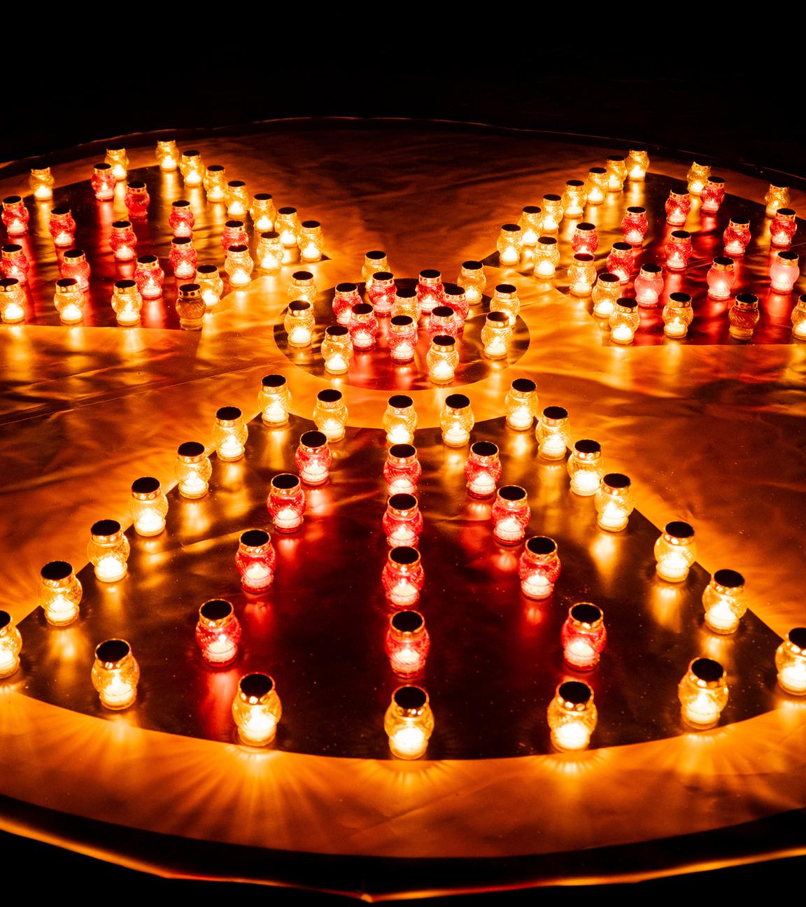 Zu sehen ist ein Reaktor-Symbol bestehend aus roten Grablichtern