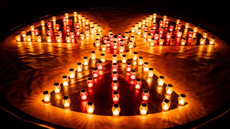 Zu sehen ist ein Reaktor-Symbol bestehend aus roten Grablichtern