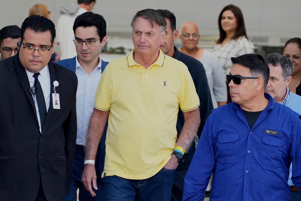 Der brasilianische Politiker Jair Bolsonaro während eines Freigangs in seinem Hausarrest, umringt von Security und Angestellten.