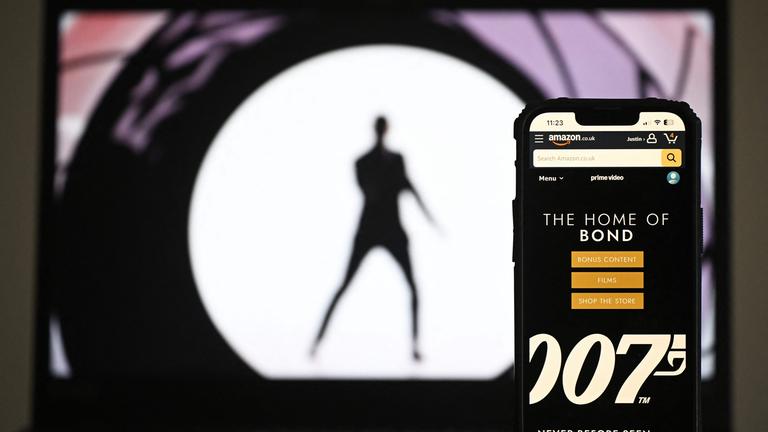 Diese am 23. Februar 2025 in London erstellte Fotoillustration zeigt die Amazon.co.uk-App „The Home Of Bond“ auf einem Handydisplay neben einem Foto auf einem Laptop-Bildschirm.