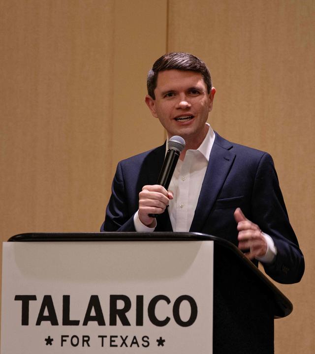 James Talarico steht auf einem Podest und spricht in ein Mikrofon.