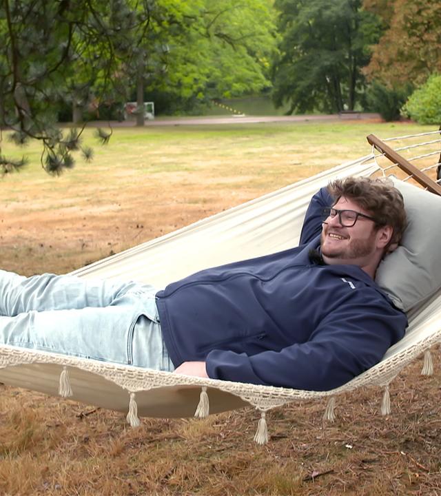 Mann mit Bart liegt in einer Hängematte