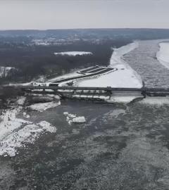 Aus der Vogelperspektive eine Landschaft und ein Fluss im Winter zu erkennen. Der Schnee schient zu schmelzen