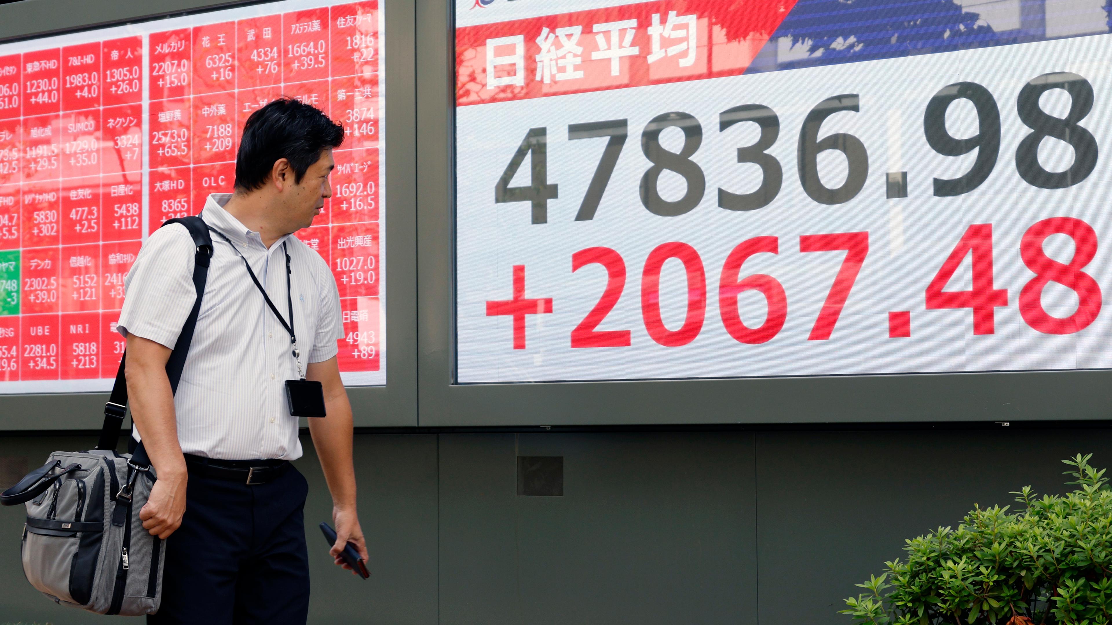 Ein Fußgänger betrachtet eine Börsenanzeigetafel in Tokio, Japan, am 06.10.2025. 