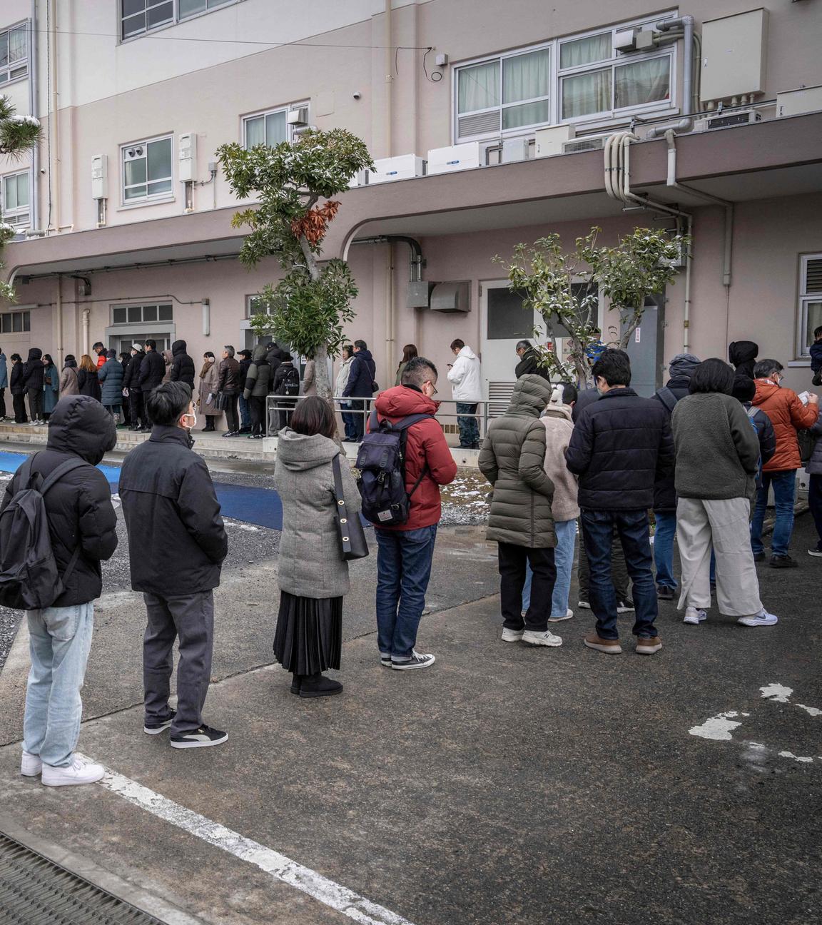 Menschen in Tokio stehen in einer Schlange vor einem Wahllokal