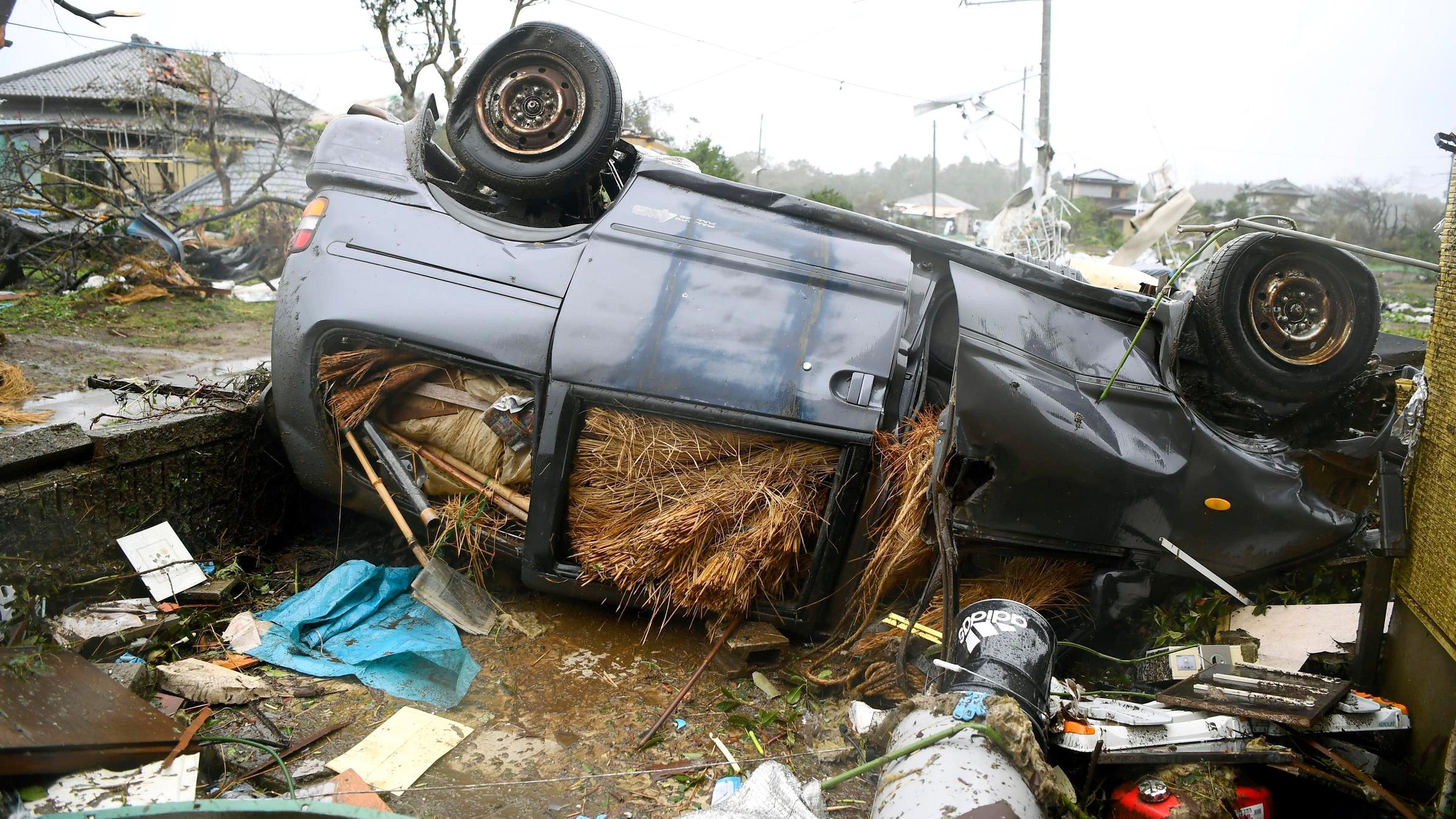 Ein durch den Sturm umgestürztes Auto liegt in Ichihara