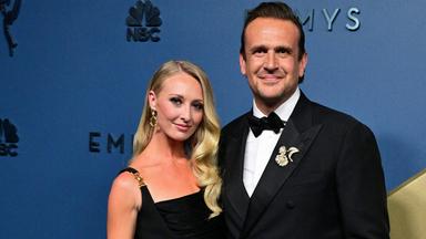 Jason Segel schaut mit seiner Frau im Arm in die Kamera.