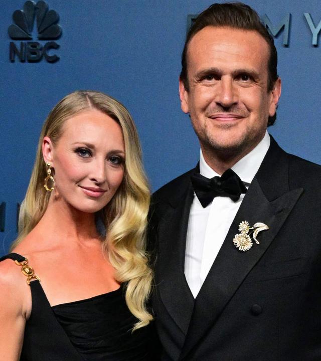 Jason Segel schaut mit seiner Frau im Arm in die Kamera.