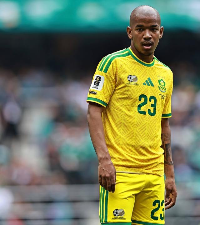 Der Fußballer Jayden Adams steht beim WM-Spiel gegen Mexiko im gelben Trikot Südafrikas auf dem Feld. 