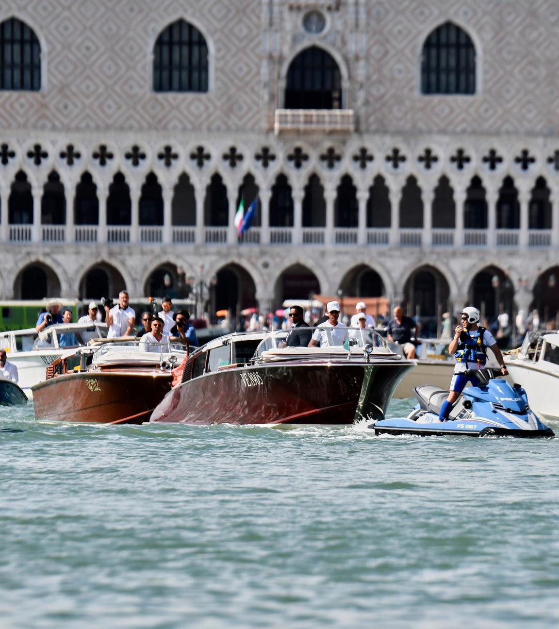 Italien, Venedig: Ein Polizeibeamter fährt vor dem Boot (M), das Lauren Sanchez transportiert, während es am Markusplatz vorbeifährt, vor den erwarteten Hochzeitsfeierlichkeiten von Jeff Bezos und Lauren Sanchez.