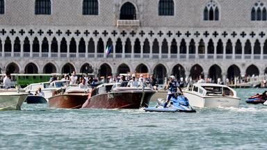 Italien, Venedig: Ein Polizeibeamter fährt vor dem Boot (M), das Lauren Sanchez transportiert, während es am Markusplatz vorbeifährt, vor den erwarteten Hochzeitsfeierlichkeiten von Jeff Bezos und Lauren Sanchez.