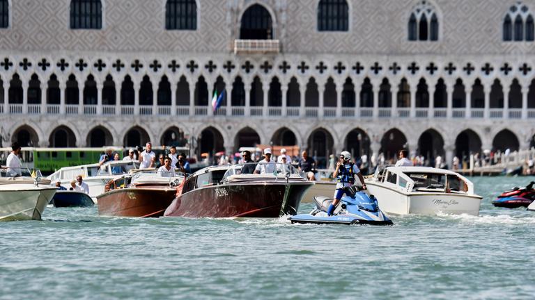 Italien, Venedig: Ein Polizeibeamter fährt vor dem Boot (M), das Lauren Sanchez transportiert, während es am Markusplatz vorbeifährt, vor den erwarteten Hochzeitsfeierlichkeiten von Jeff Bezos und Lauren Sanchez.