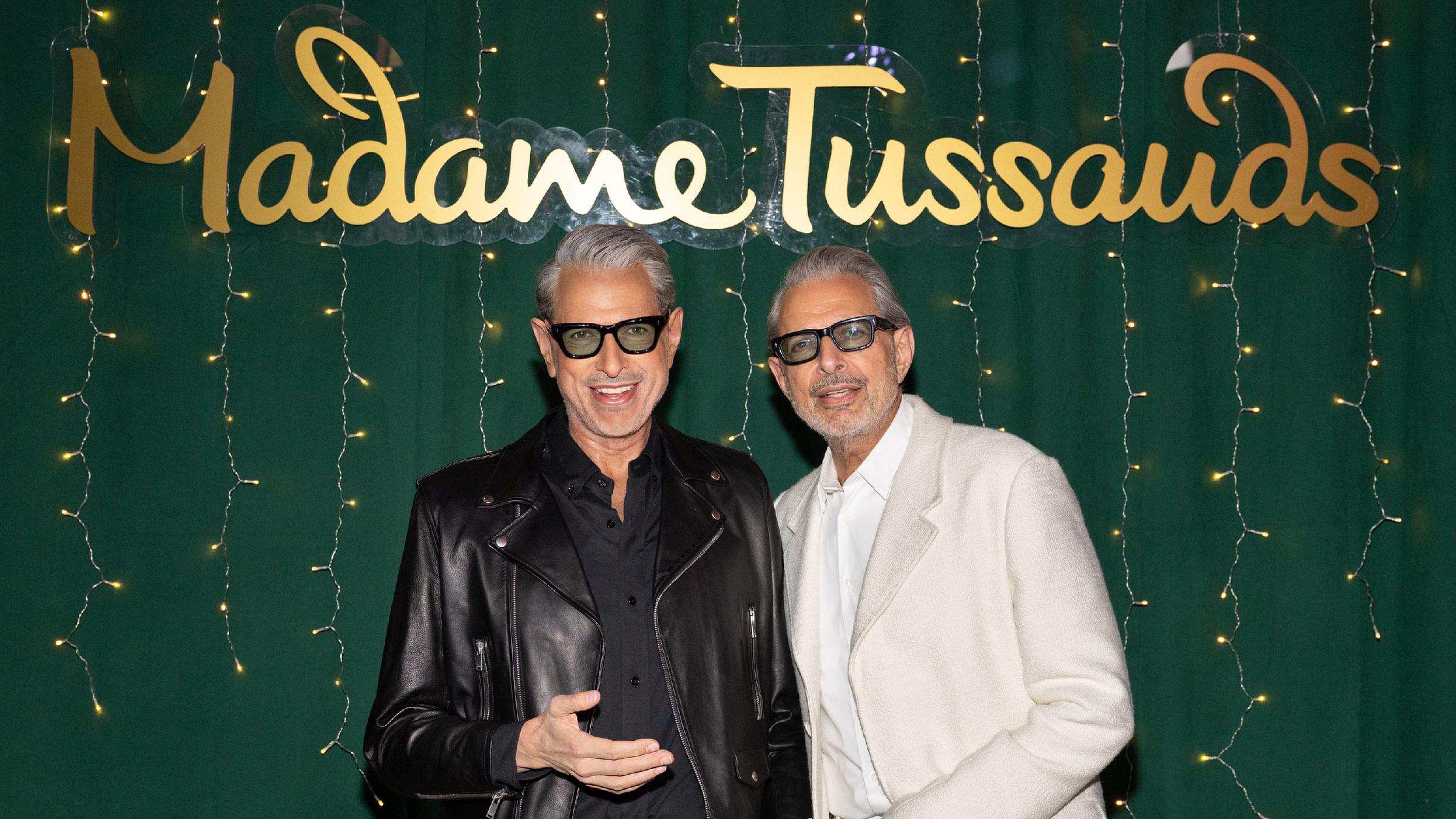Der Schauspieler Jeff Goldblum posiert neben seinem Doppelgänger aus Wachs. Im Hintergrund ist der Schriftzug "Madame Tussauds" zu lesen.