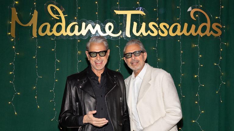 Der Schauspieler Jeff Goldblum posiert neben seinem Doppelgänger aus Wachs. Im Hintergrund ist der Schriftzug "Madame Tussauds" zu lesen.