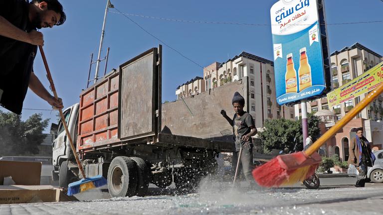 Jemeniten reinigen Trümmer vor ihren Geschäften nach einem US-Luftangriff in Sanaa, Jemen, aufgenommen am 16.03.2025