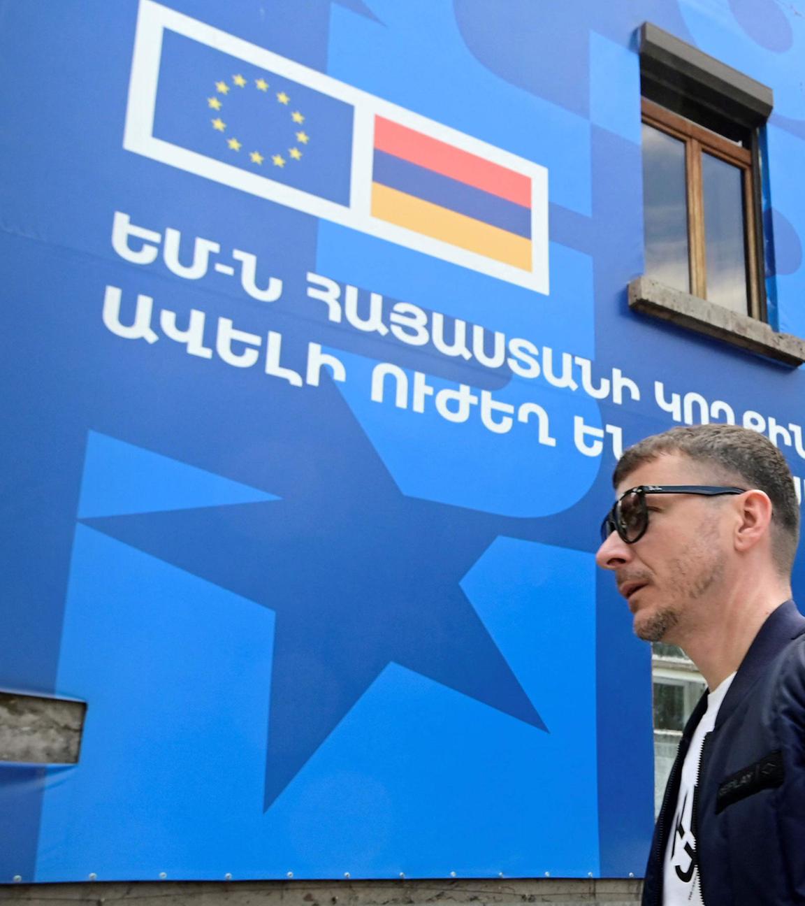 Fußgänger laufen an einem Poster vorbei, dass den EU-Armenien-Gipfel in Jerewan ankündigt.