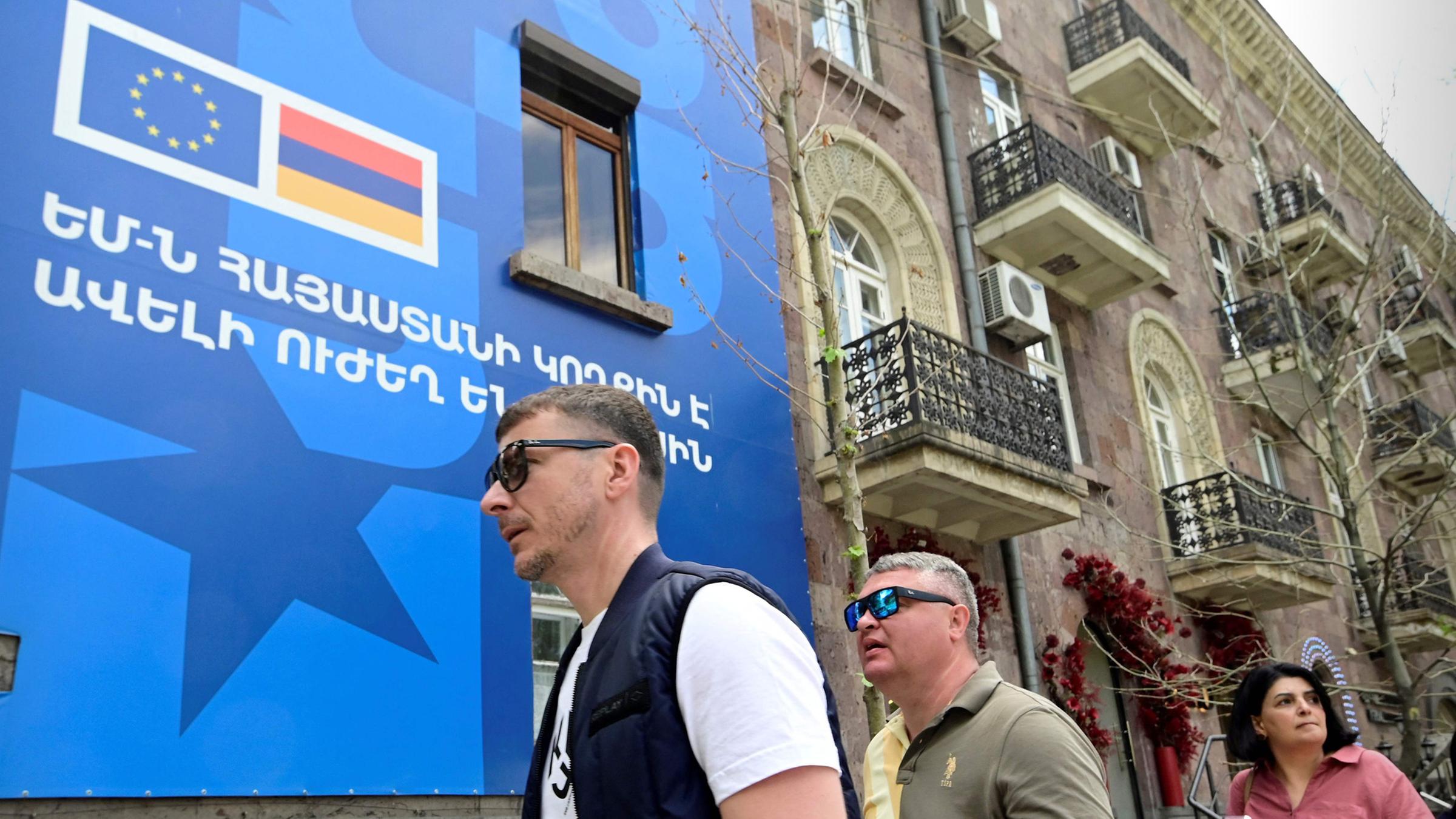 Fußgänger laufen an einem Poster vorbei, dass den EU-Armenien-Gipfel in Jerewan ankündigt.