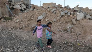 In Shingal im Irak gibt es schwere Zerstörung: Kinder spielen in Trümmern.