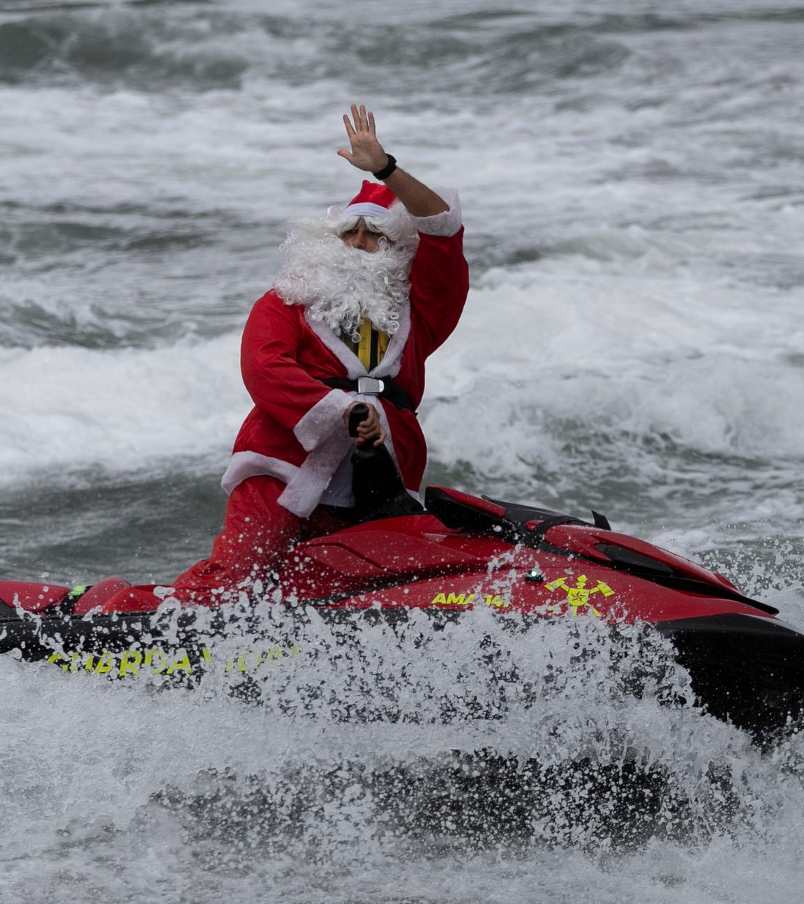 Ein als Weihnachtsmann verkleideter Mann sorgt auf einem Jetski an der Copacabana für leuchtende Kinder-Augen