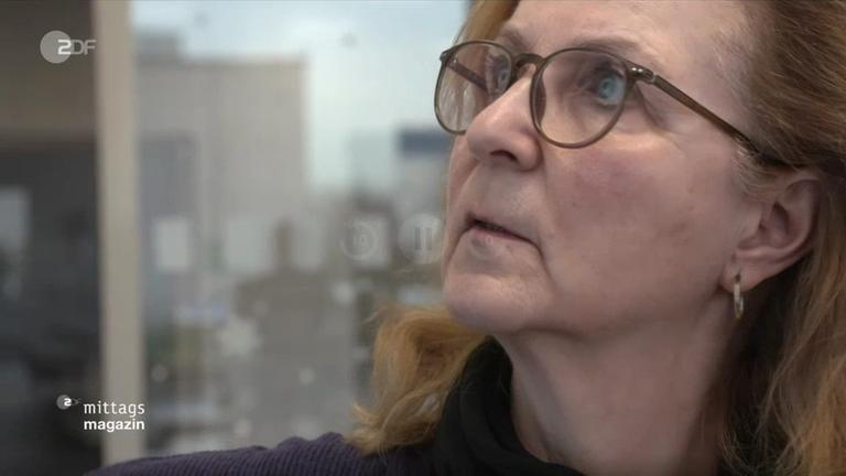 Frau guckt besorgt auf eine Tafel