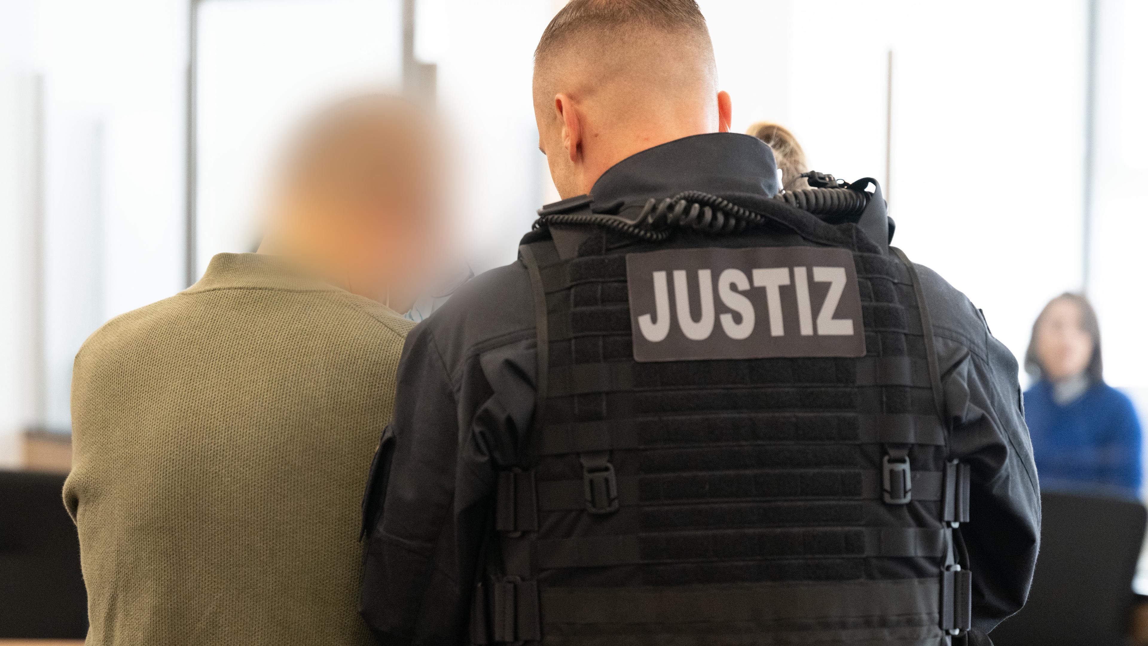 30.09.2025, Sachsen, Dresden: Der Hauptangeklagte Jian G. wird vor Prozessbeginn in den Gerichtssaal geführt.