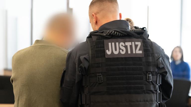 30.09.2025, Sachsen, Dresden: Der Hauptangeklagte Jian G. wird vor Prozessbeginn in den Gerichtssaal geführt.