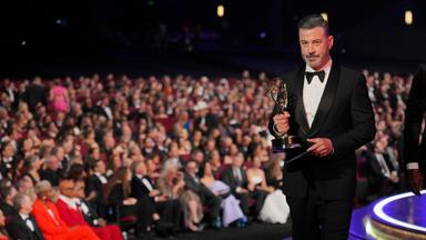 Jimmy Kimmel mit einem Emmy in der Hand. Er läuft auf die Bühne. Hinter ihm sieht man das Publikum