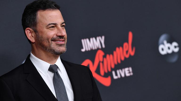 Der Late-Night-Show-Host Jimmy Kimmel steht auf dem Roten Teppich und lächelt.