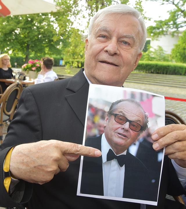 Ein Mann zeigt auf ein ausgedrucktes Foto. 