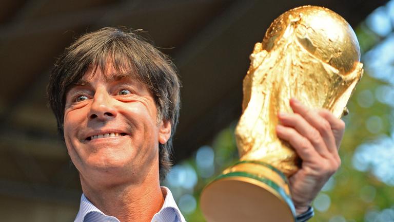 Joachim Löw hält den WM-Pokal in den Händen.