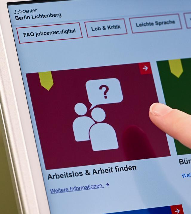 Auf einem Display im Jobcenter Lichtenberg werden Onlineangebote (Arbeitslos) und (Arbeit finden) angezeigt-
