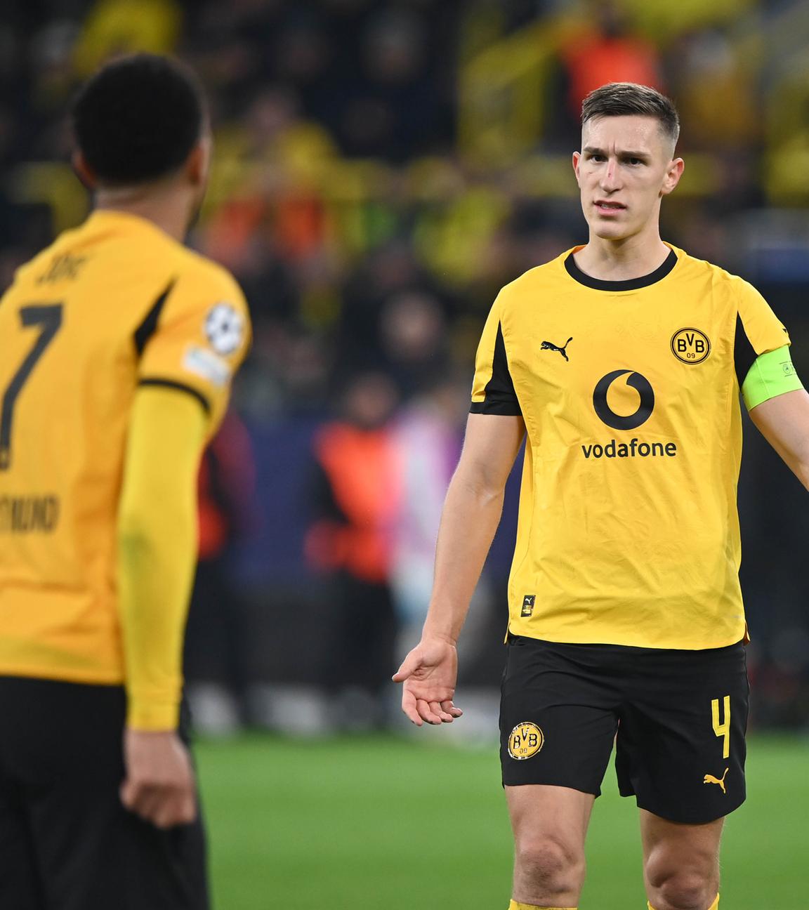 Fußballer Jobe Bellingham (links) und Nico Schlotterbeck von Borussia Dortmund, stehend gestikulierend auf dem Spielfeld am 10.12.2025 in Dortmund.