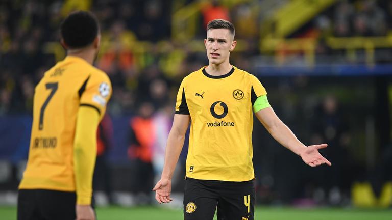 Fußballer Jobe Bellingham (links) und Nico Schlotterbeck von Borussia Dortmund, stehend gestikulierend auf dem Spielfeld am 10.12.2025 in Dortmund.