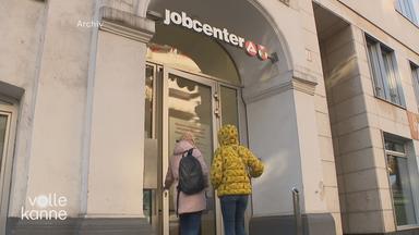 Das Bild zeigt zwei Personen, die zum Jobcenter gehen.
