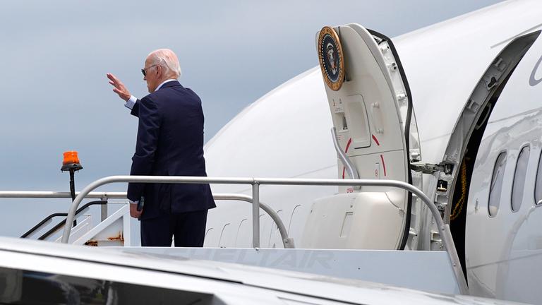 Joe Biden winkt beim Einstieg in sein Flugzeug.