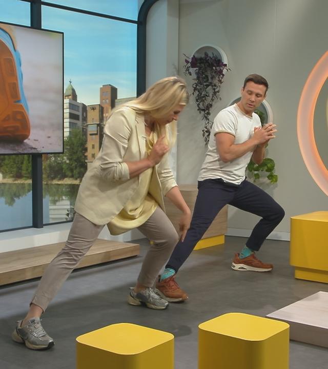 Sportmediziner Dr. Christophe Lambert zeigt Nadine Krüger Dehnübungen.