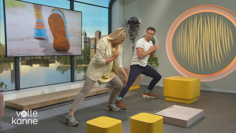 Sportmediziner Dr. Christophe Lambert zeigt Nadine Krüger Dehnübungen.