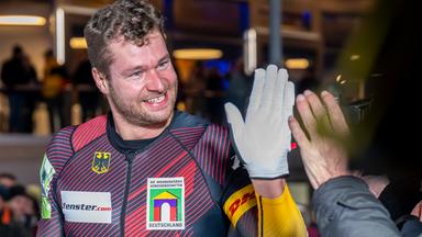 Johannes Lochner aus Deutschland klatscht beim Bob-Weltcup in Winterberg im Zielbereich mit einem Fan ab. 