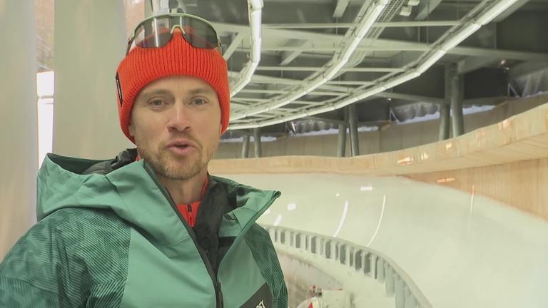 Johannes Ludwig steht neben der Olympia-Rodelbahn in Cortina