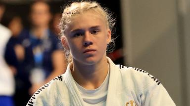 Judoka Jolina Reichold steht im weißen Judoanzug mit schwarzem Gürtel auf der 
