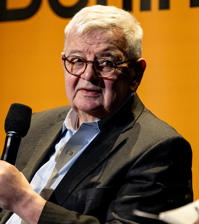Joschka Fischer, ehemaliger Außenminister, sitzt bei der Buchvorstellung von Wer sind wir?" in der Urania auf der Bühne