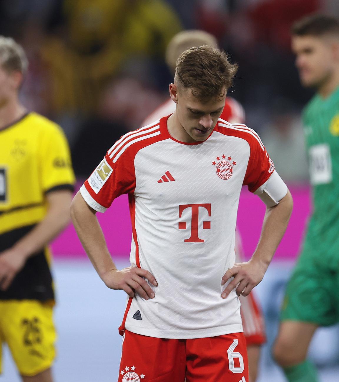 Joshua Kimmich reagiert, während Dortmunds Spieler nach dem Bundesligaspiel zwischen dem FC Bayern München und Borussia Dortmund in München, Deutschland, 30.03.2024, feiern.