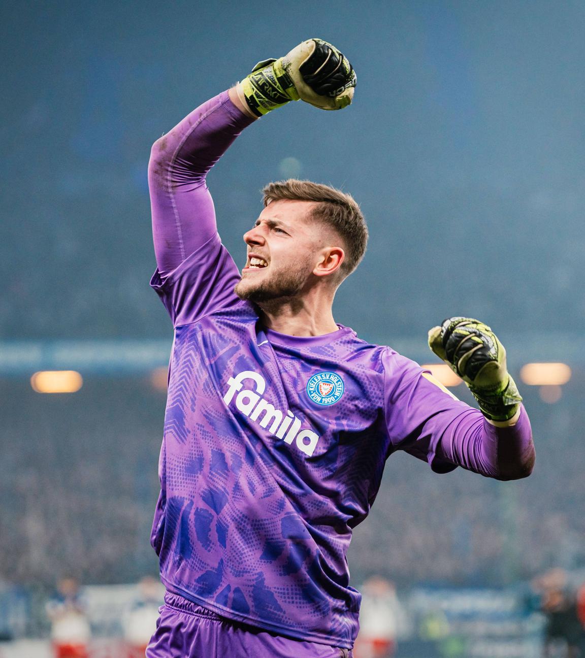 Timon Weiner hebt nach dem Sieg im Elfmeterschießen gegen den HSV vor der Gästekurve jubelnd seinen Arm 